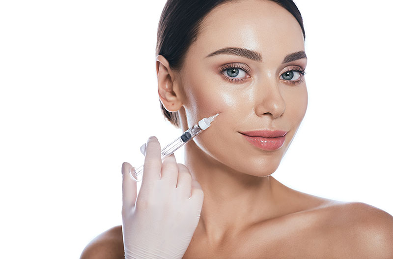 Beautician doing injections dermal fillers into female cheeks Beautician doing injections dermal fillers into female cheeks